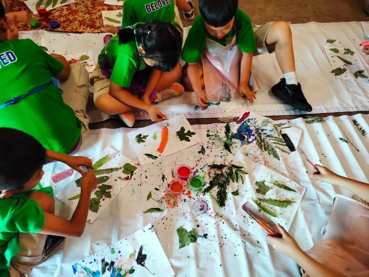 Anak-anak Sekolah Alam ALFA OMEGA melukis menggunakan daun dan cat alami di alam terbuka